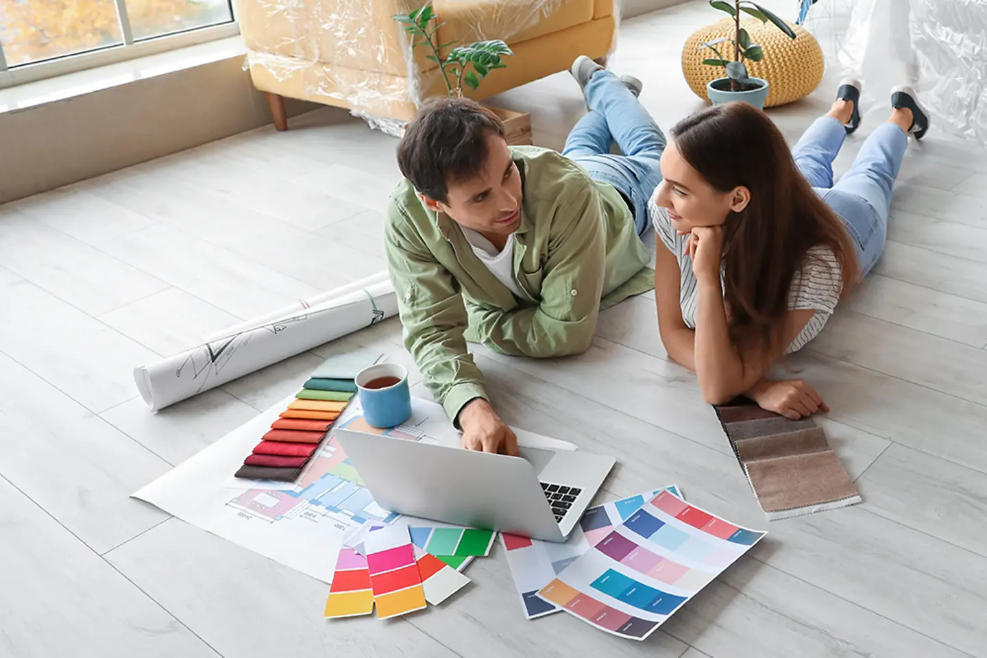 Junges Paar renoviert Wohnung, wählt online Bodenbelag und Wandbekleidung aus.