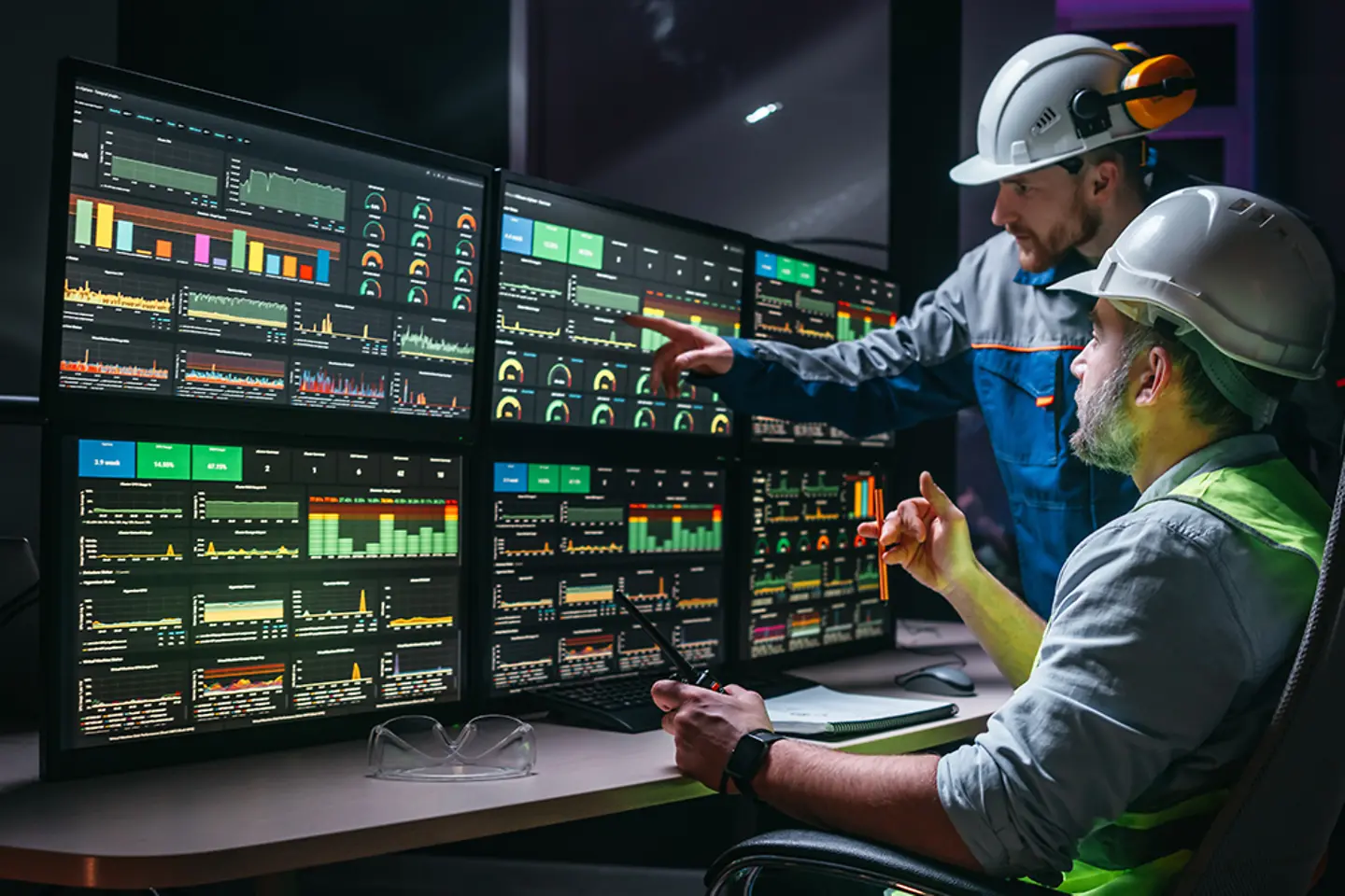Head engineer and worker following factory production line uses screens with Industry 4.0 software. 