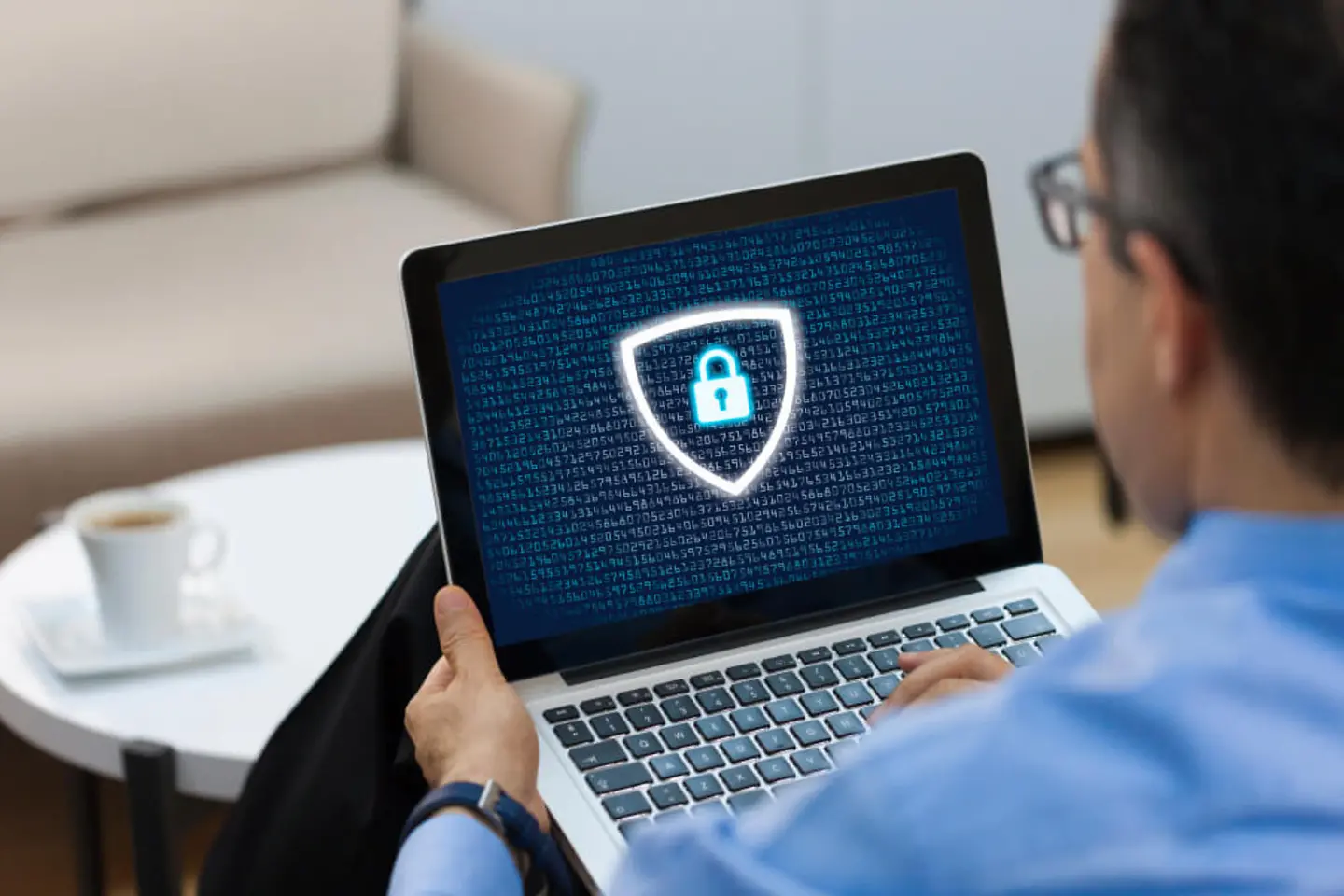 Homem com laptop, logotipo de proteção de dados na tela.