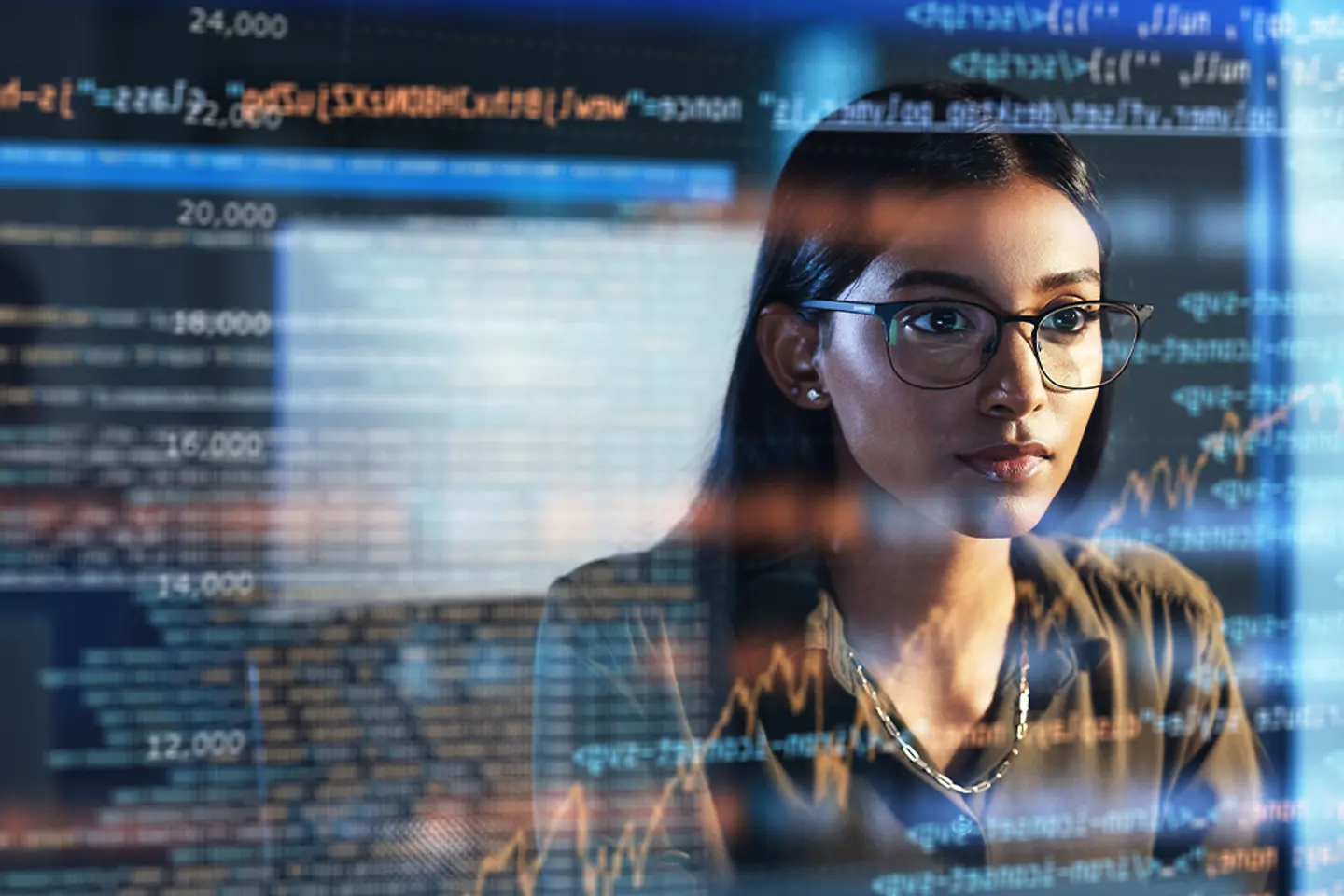 Eine IT-Fachfrau liest ein Skript oder ein Programm auf einem digitalen Bildschirm.