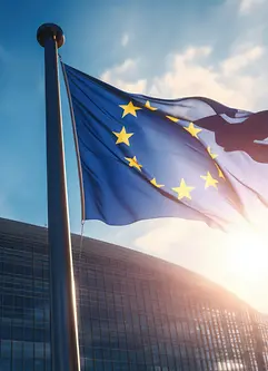 EU flag waving in front of modern building with sunshine - AI generated/adapted