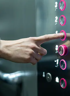 Person in an elevator pushing magenta button