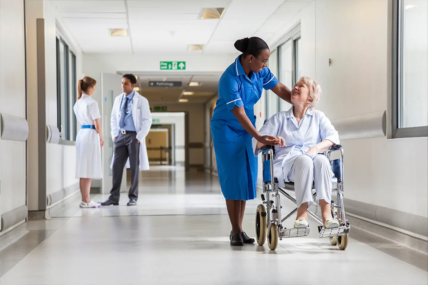 A nurse in a hospital talking with an elderly patient