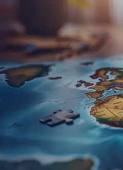  Man placing a puzzle piece on a colorful world map