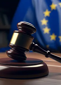 Judge's gavel on wooden table and European Union flag