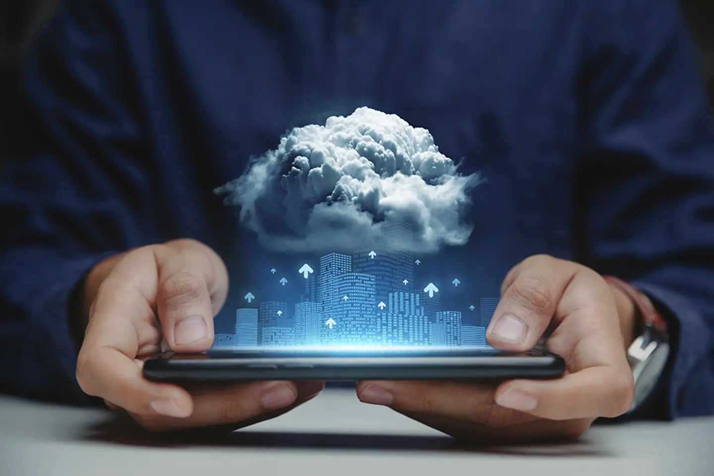 Man holding tablet with skyscrapers and cloud above