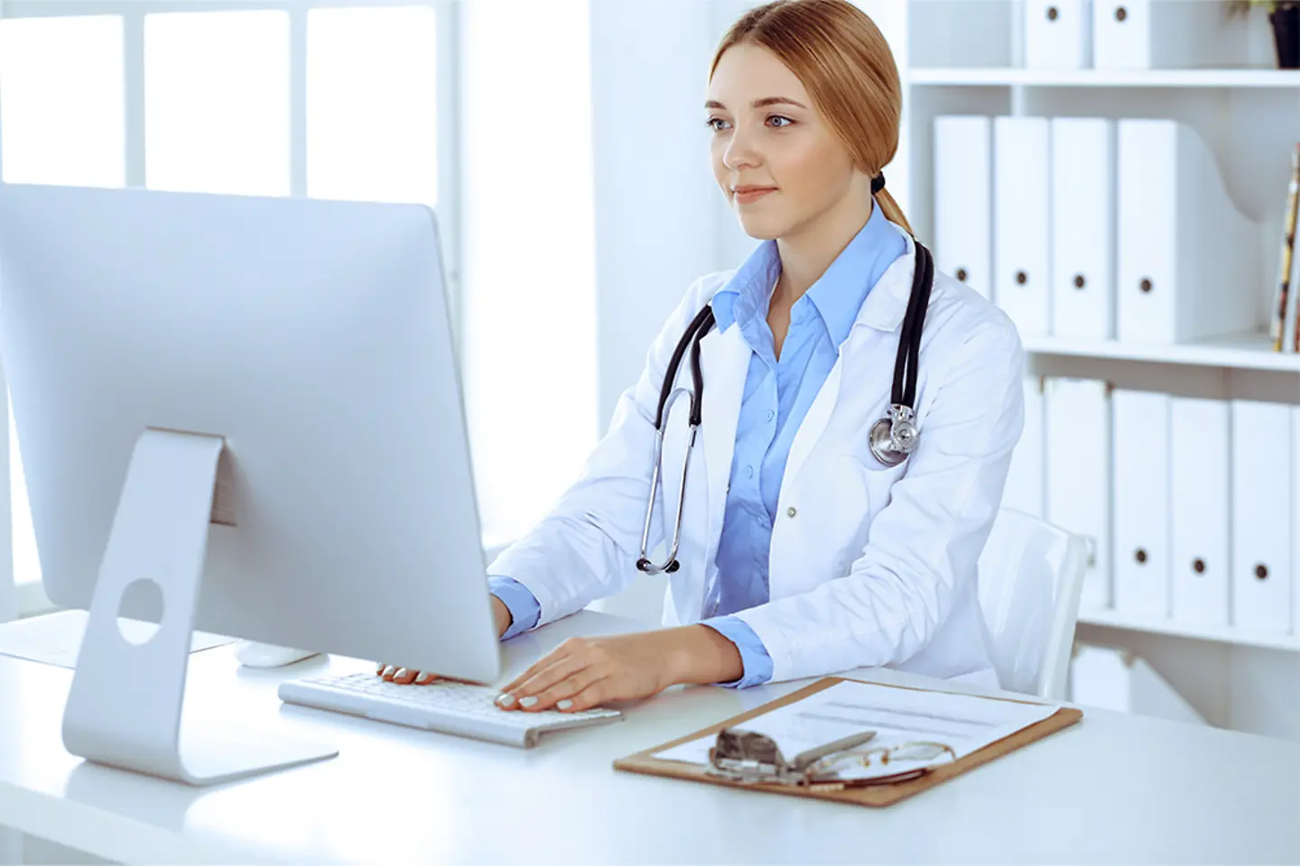 Une femme médecin en train de taper sur un clavier 