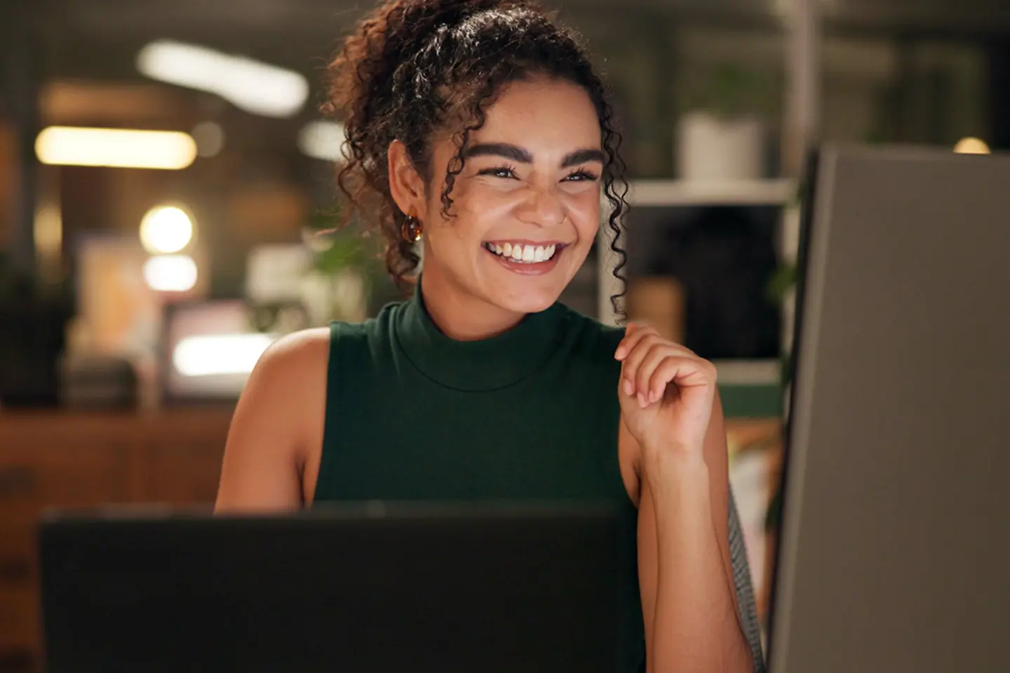 Mulher jovem rindo no computador