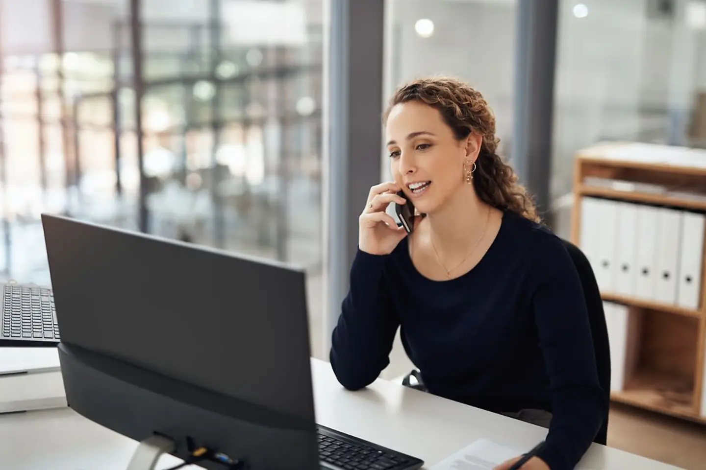 La femme utilise un ordinateur portable et parle au téléphone