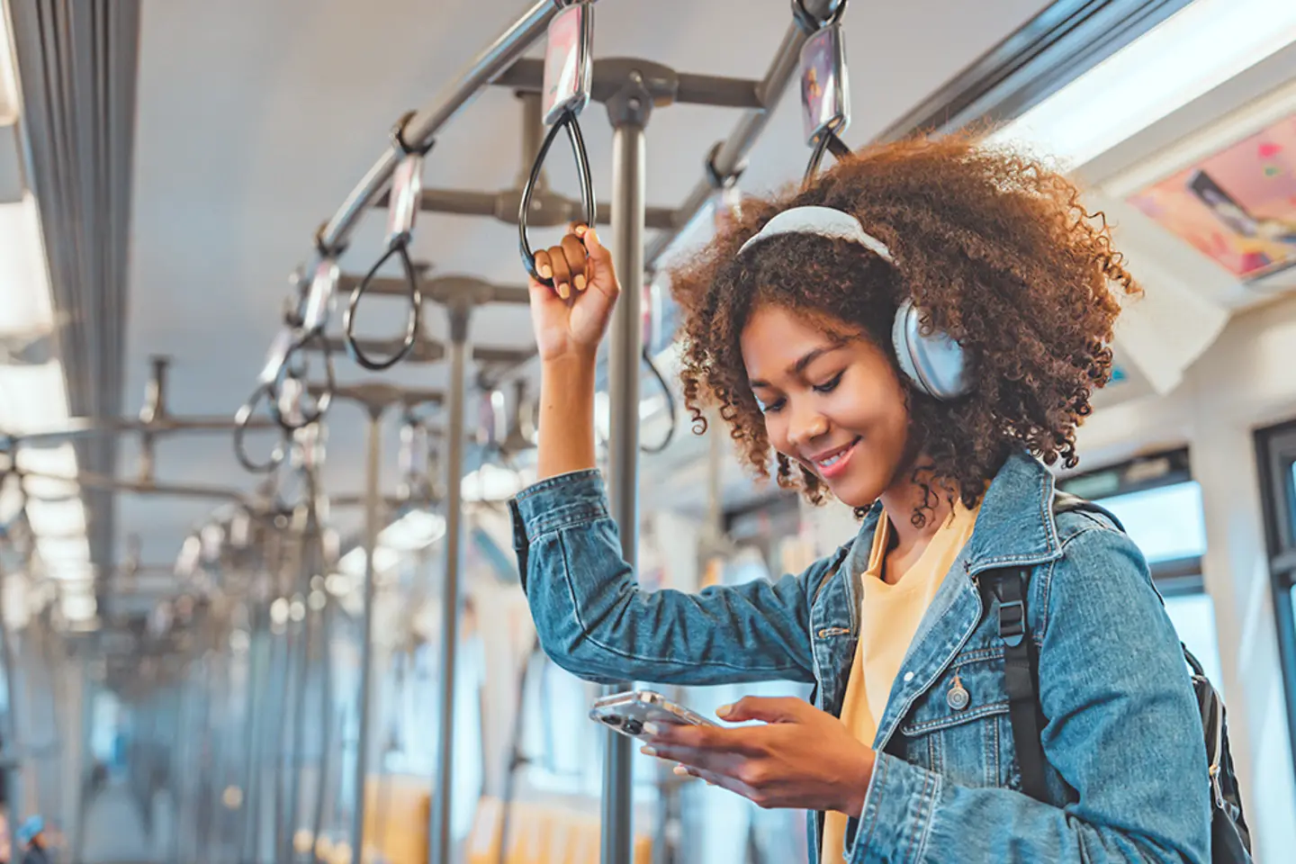 Happy woman train passenger listening to music on smartphone