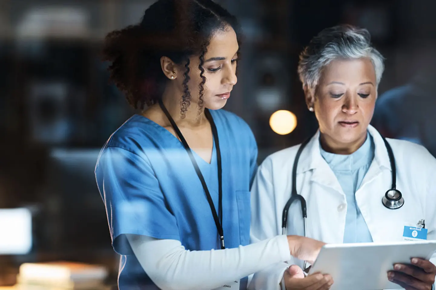 Doctor and nurse analyze data on tablet