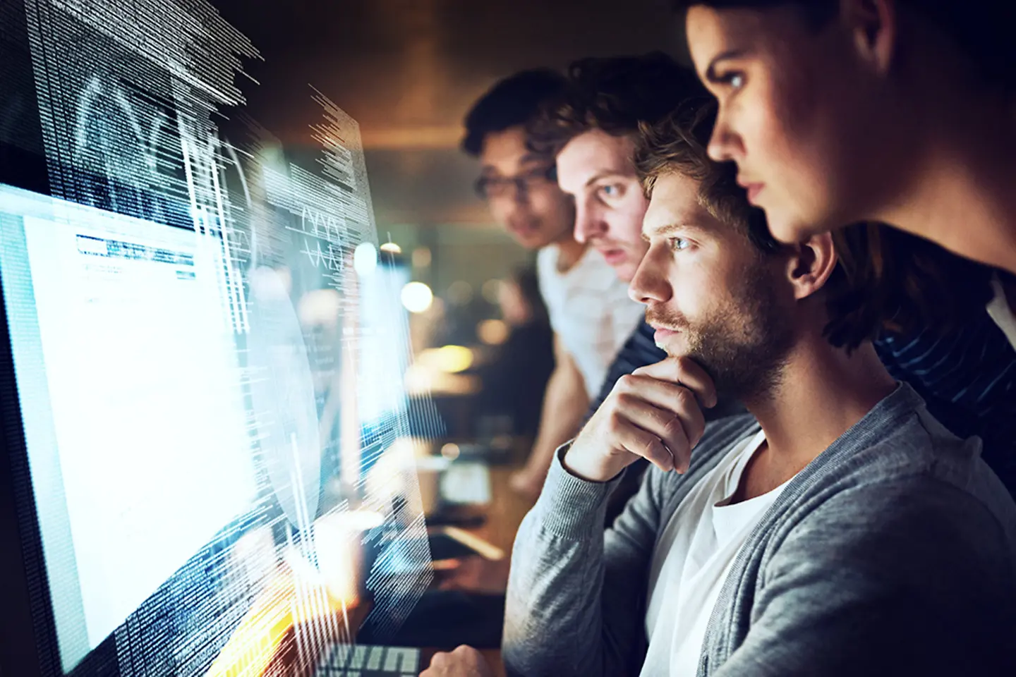 Grupo de programadores trabajando de noche en un código informático